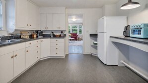 Eine moderne Küche mit weißen Schränken, einem Einbauofen und einer Arbeitsplatte mit einem Toaster.
