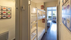 A corridor with bunk beds, a radiator, and a wall with colorful lip prints.