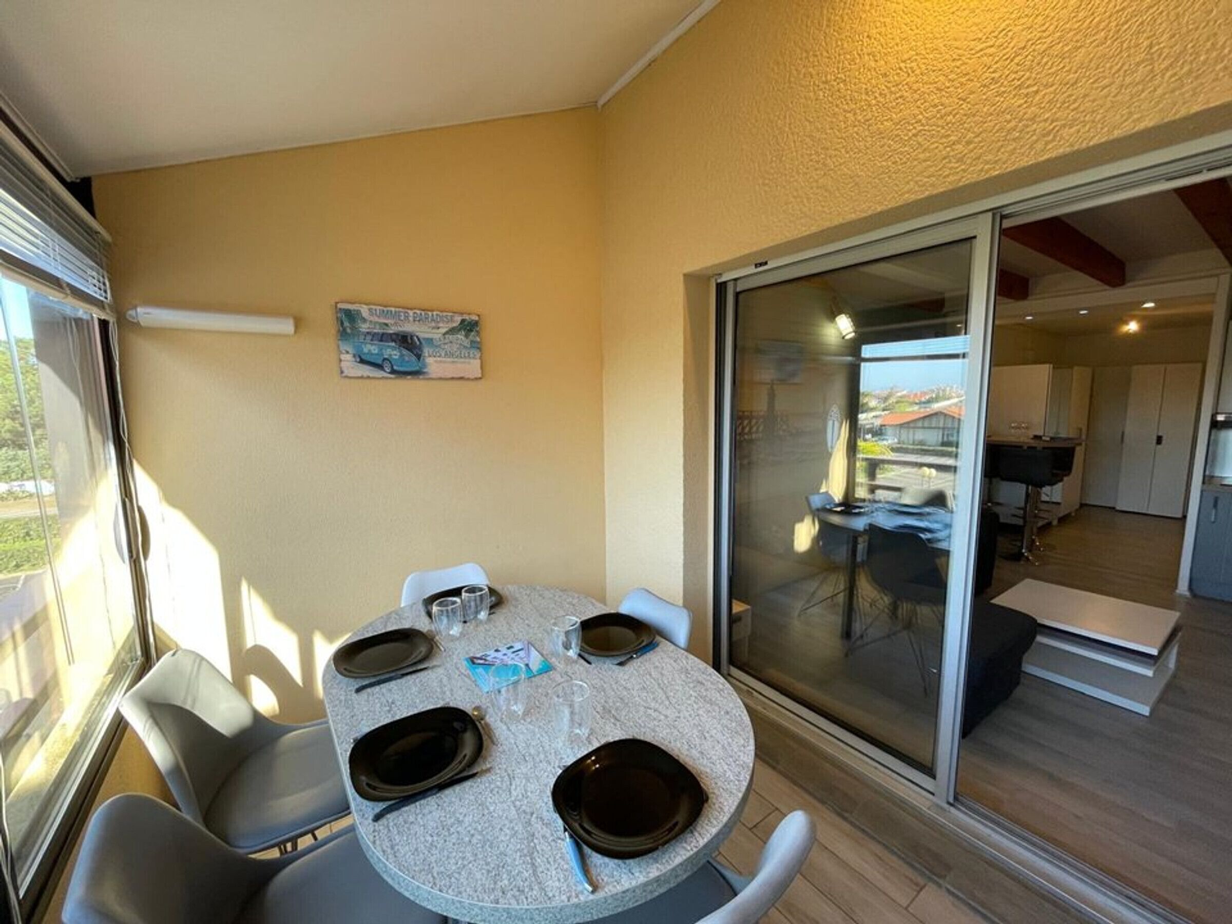 A dining area with a round table, chairs, and a glass partition.