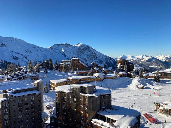 A snow-covered mountain resort with wooden buildings and ski slopes.