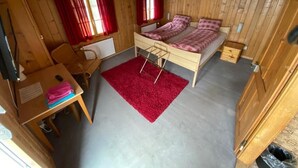 A small wooden cabin with a bunk bed, a desk, and a red rug. - Berggasthaus Rigi Burggeist (Gersau)