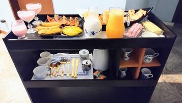 Un bufé de desayuno con diversos alimentos y bebidas.