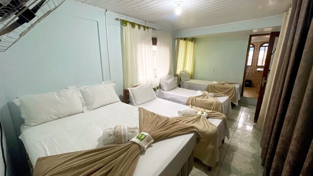 A hotel room with two beds, a bathroom, and a shower area. - Pousada da Praia Frade (Angra dos Reis)
