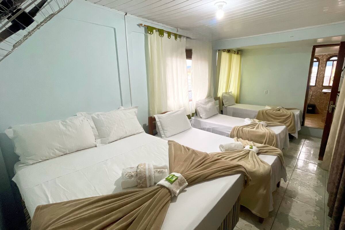A hotel room with two beds, a bathroom, and a shower area.