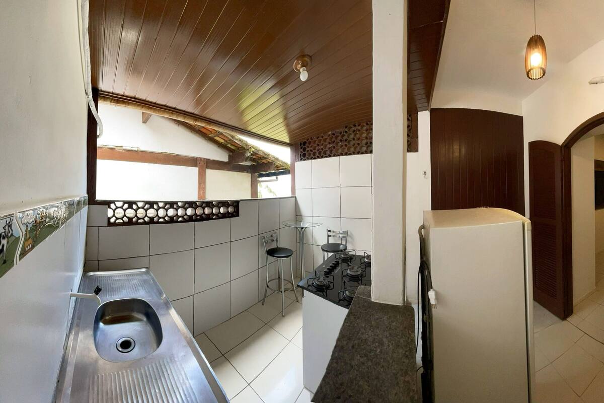 A compact bathroom with a sink, toilet, and shower.