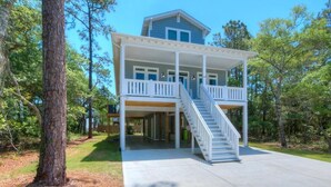 A two-story house with a covered porch and a staircase leading to the upper level.
