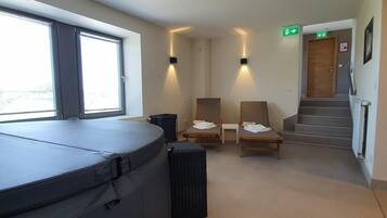 Relax in comfort with a massage table and plush seating area.