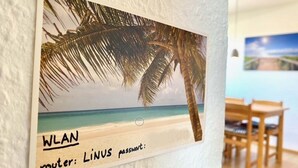 A wall-mounted sign with a beach scene and WLAN information. - Ferienresort in Fehmarn-lemkenhafen (Fehmarn)