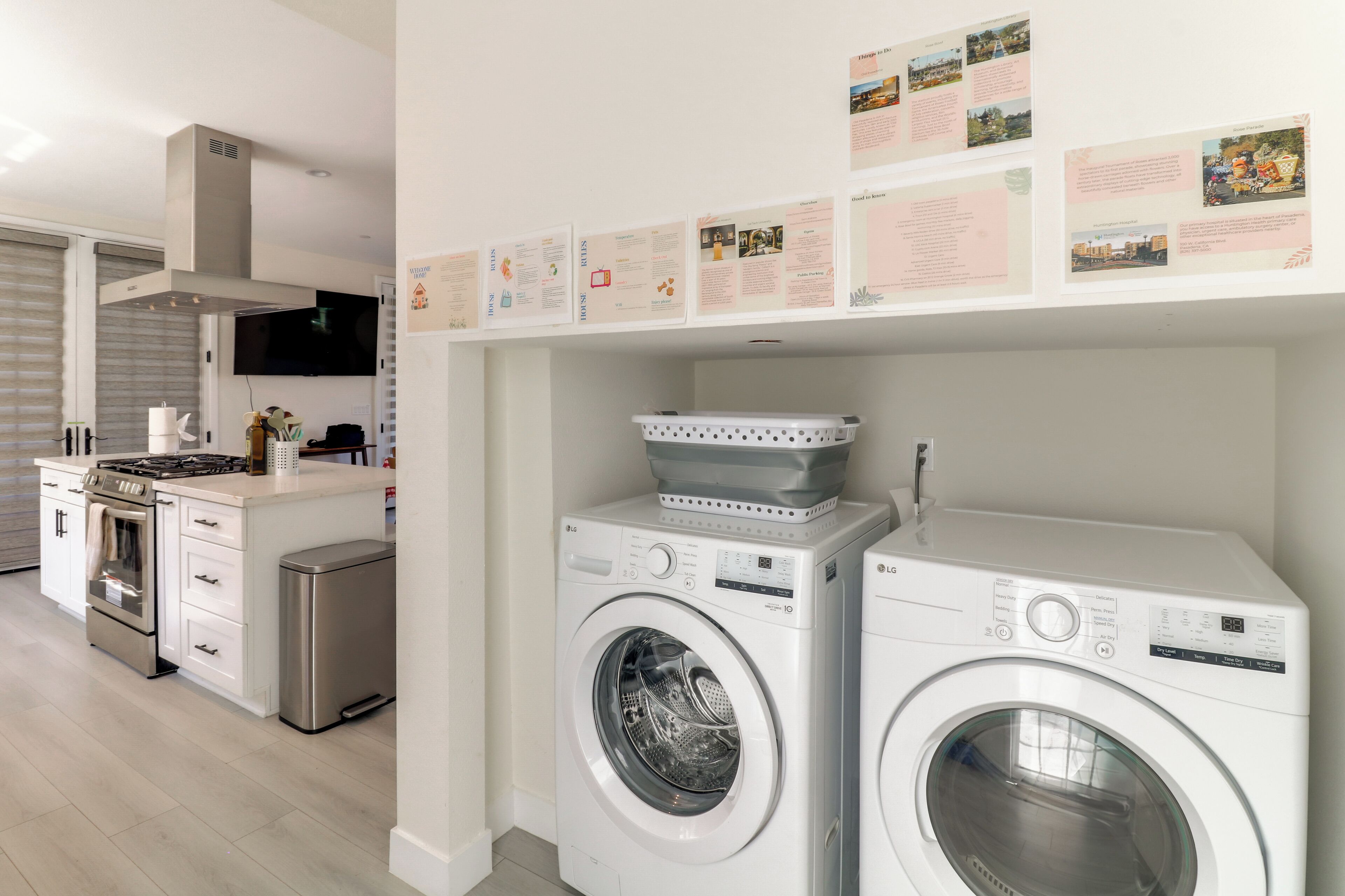 Une cuisine moderne dotée d  ’appareils électroménagers intégrés, un espace buanderie avec deux machines à laver et des affiches informatives accrochées au mur.