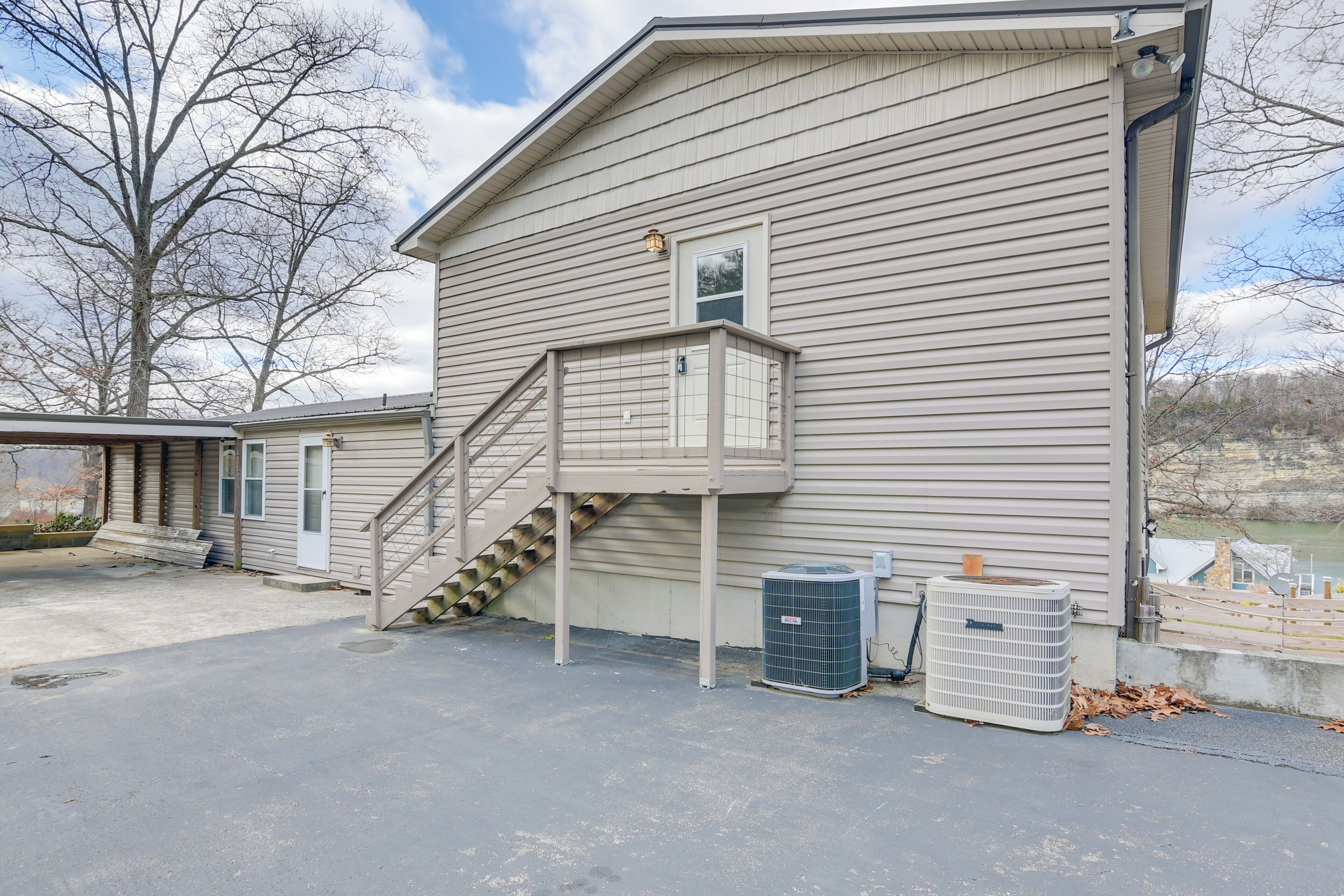 A two-story house with a front porch, a staircase, and an air conditioning unit.
