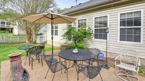 A patio with a round table and chairs, a large umbrella, and a potted plant. - 3 Mi to Old Hickory Lake: Family-friendly Getaway! (Old Hickory)