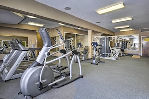 A gym with treadmills, elliptical machines, and weight machines.