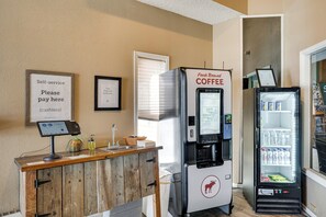 Un espace de libre-service où l'on peut se servir du café, équipé d'un distributeur de boissons réfrigéré et d'un réfrigérateur pour les boissons.