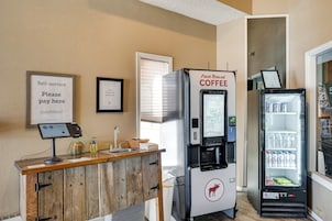 A self-service coffee station with a refrigerated beverage dispenser and a refrigerated drink cooler.