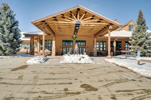 A building with a covered entrance, snow accumulation, and a sign indicating handicapped parking.
