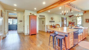 A spacious kitchen with a large island, wooden cabinets, and a farmhouse-style ceiling. - 3 Mi to Dtwn: Charming Farmhouse in Mount Joy! (Mount Joy)