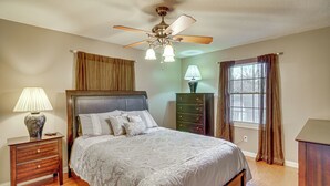 A bedroom with a bed, nightstand, dresser, window with curtains, and a ceiling fan. - 2 Mi to Lake Cumberland Access: Home w/ Grill (Jamestown)