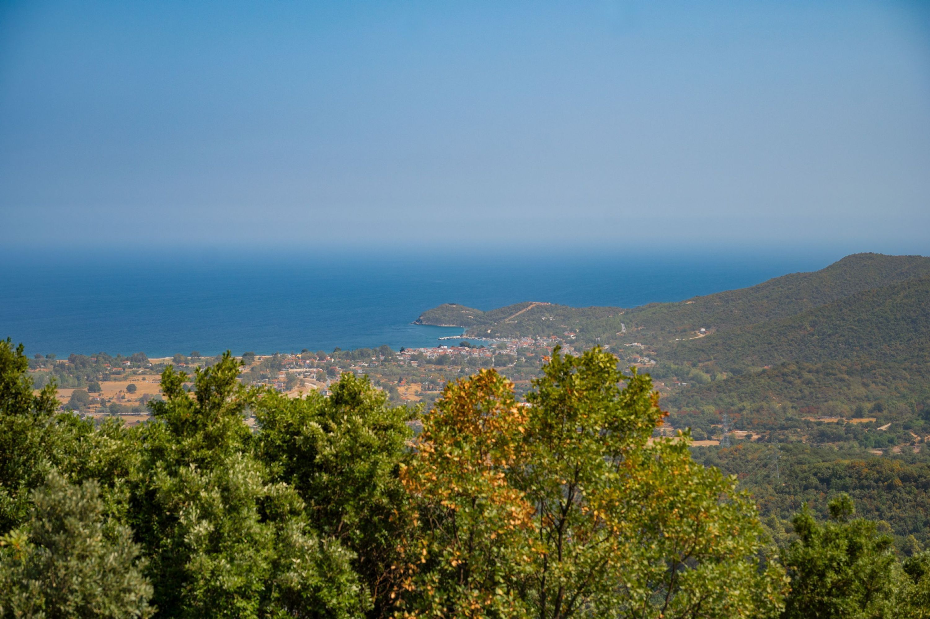 Un paysage côtier offrant une vue sur la mer et les collines.
