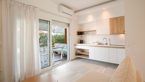 A modern kitchen with white cabinets, a wooden countertop, and a built-in oven. - Aristi House in Olimpiada (Aristotelis)