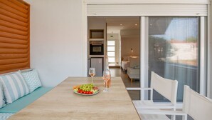 A dining area with a wooden table, a plate of fruit, and a bottle of wine. - Aristi House in Olimpiada (Aristotelis)