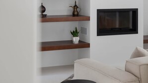 A modern living room with built-in wooden shelves, a flat-screen TV, and a beige sofa. - Casa da F in Parchal (Lagoa)