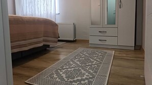 Une chambre à coucher avec un lit, une armoire et un tapis à motifs.
