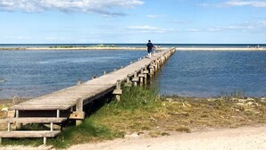 A wooden pier extending into a body of water with a clear sky above.