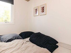 A bedroom with a bed, two pillows, a window, and two framed artworks on the wall. - 6 Person Holiday Home in Hadsund (Hadsund)