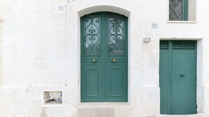 A building with a green door and a window with decorative ironwork.