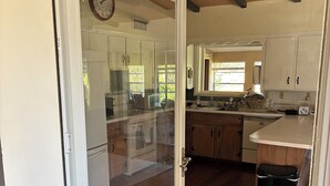 A kitchen with wooden cabinets, a stainless steel sink, and a clock on the wall.