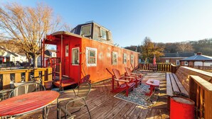 Un barco rojo con cubierta, equipado con sillas de metal, una mesa y un banco.