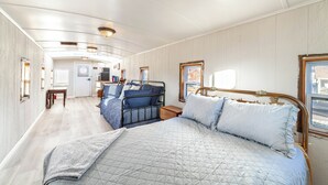Una habitación amplia y bien iluminada con una cama grande, una mesa pequeña y una silla.