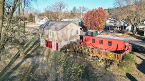 Una casa con un vagón de tren rojo adosado a un lado.