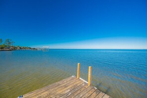 A wooden pier extending into calm waters with a clear sky above. - Bayside Bungalow 9531 3 Bedroom Home (Gulf Shores)