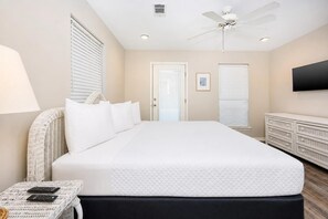 A bedroom with a large bed, a ceiling fan, a TV, and a dresser. - Bayside Bungalow 9531 3 Bedroom Home (Gulf Shores)