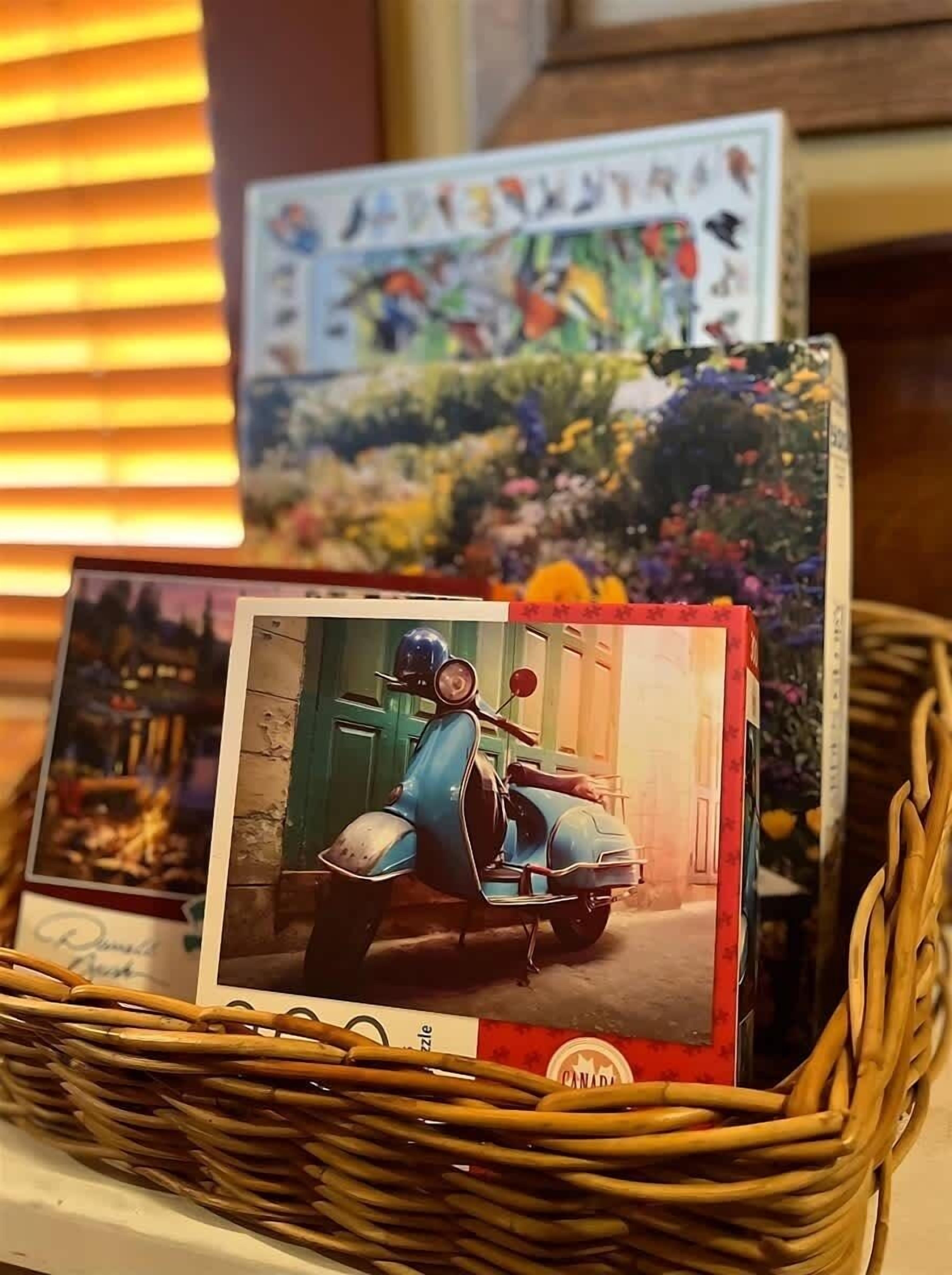 A basket containing a card with a vintage scooter and a card with a floral garden scene.