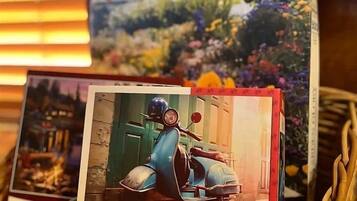A basket containing a card with a vintage scooter and a card with a floral garden scene.