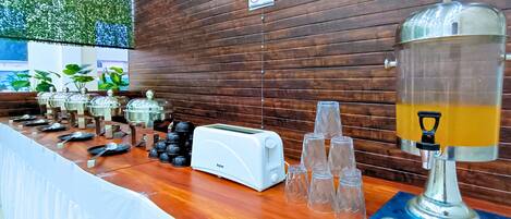 A breakfast bar with a toaster, a coffee machine, and a glass dispenser.