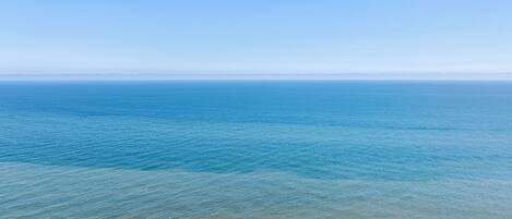 Une plage avec une eau d’un bleu limpide et un rivage sablonneux.