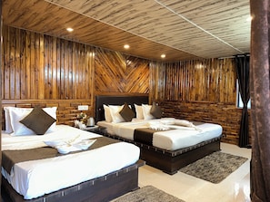Ein modernes Hotelzimmer mit zwei Betten, Holzwandverkleidung und einer Holzbalkendecke.