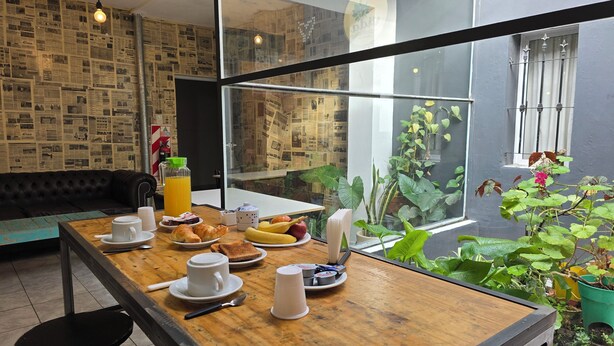 A breakfast table with croissants, fruit, and a jug of orange juice. - Hotel Vida (Puerto Madryn)