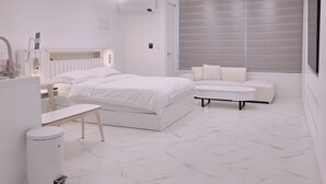 A modern bedroom with a bed, a sofa, a desk, and a trash bin. - 5sec dongmyo station apartment (Seoul)