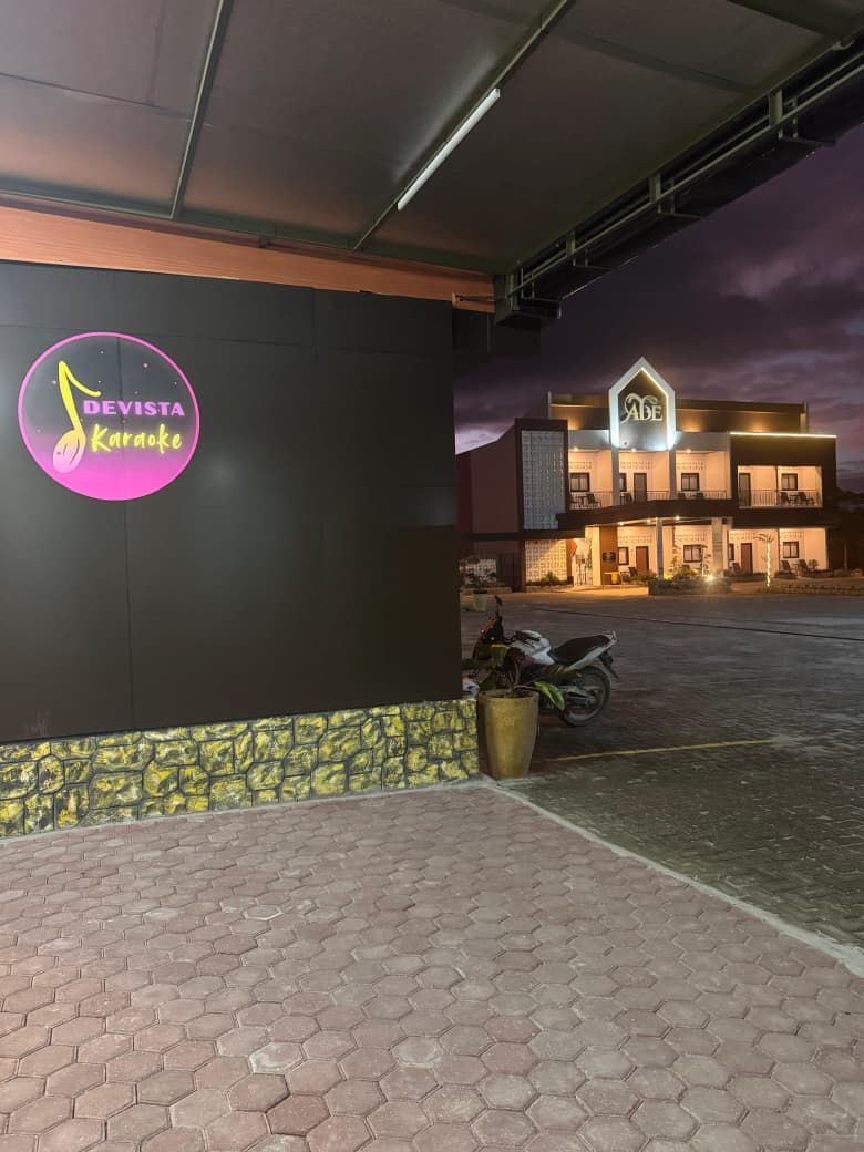 Un edificio con un cartel que dice 'Devista Karaoke' y otro que dice 'Abe'.