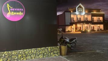 Un edificio con un cartel que dice 'Devista Karaoke' y otro que dice 'Abe'.
