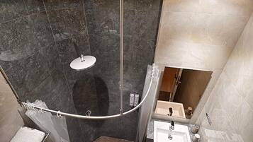 A compact bathroom with a shower, toilet, and sink.