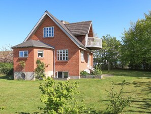Standalone house with a gabled roof and a small balcony.