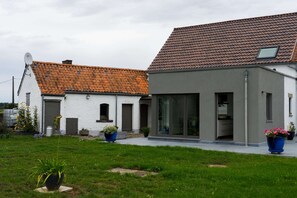 A two-story house with a tiled roof, a satellite dish, and a modern extension with large glass doors. - Charming Cottage With Sauna (Honnelles)