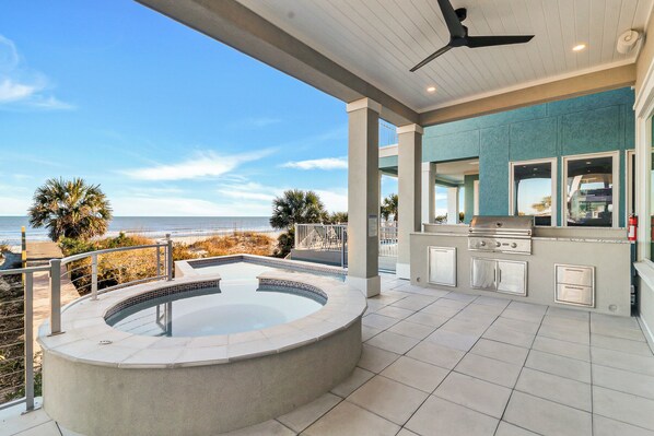 A pool area with a hot tub, outdoor kitchen, and a view of the beach. - Beautiful New Beach Home with Private Pool, Spa & Stunning Beach Views (Hilton Head Island)