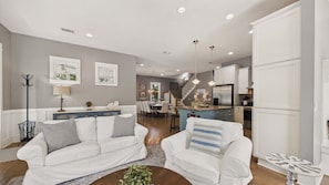 A modern living room with a sofa, armchairs, a coffee table, and a dining area with a chandelier. - Morgans 125–Private Beach Access–Sleeps 11 (Santa Rosa Beach)