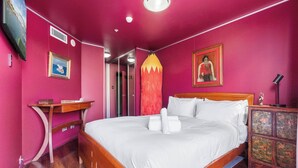 A room with a wooden bed, a nightstand, a dresser, and a mirror.